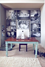 a home office with a black and white gallery wall with unframed pics that cover the whole wall and make a statement