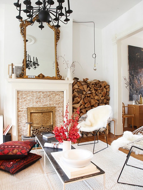 An eclectic space with a non working and very refined fireplace and firewood stored between it and the wall for maximal coziness