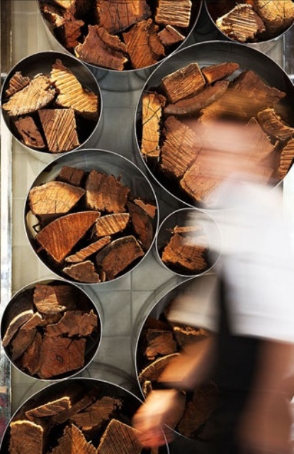 a modern and laconic wall storage unit of metal pipes can be used not only for firewood but for other stuff, too, and is a decor feature at the same time