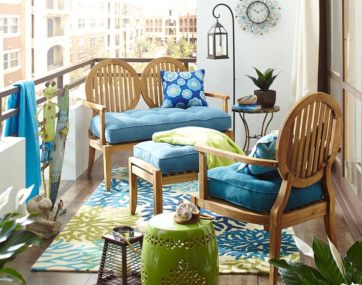 A bright and cheerful summer balcony done in blue and green, with chic vintage inspired furniture and bright textiles