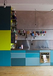 a creatively bright kitchen with bright and metallic blue cabinets and neon green parts, with a stainless steel backsplash and countertops is bold and cool