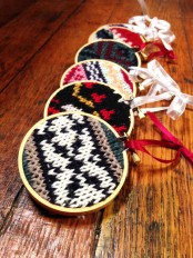 an assortment of colorful knit Christmas ornaments made using embroidery hoops – you may knit them or upcycle your old sweaters
