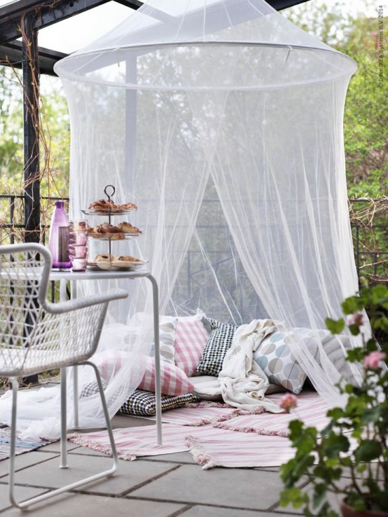 a terrace with a pillow space with rugs and a mosquito net over - invite your kids to spend time there without any bugs