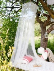 a daybed with a mosquito net over it, with pillows and lanterns to create your own outdoor oasis for relaxation