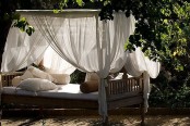 an outdoor daybed with canopy curtains and lots of pillows is a very relaxing idea to try