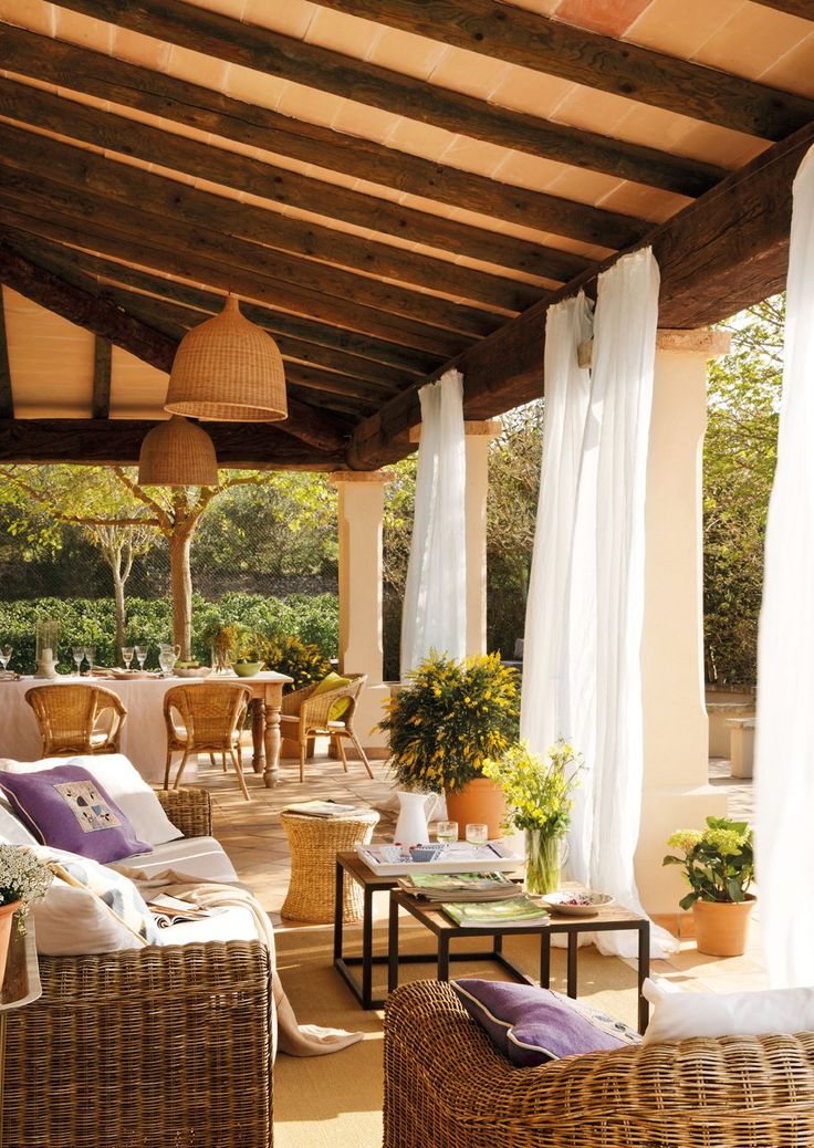 A welcoming rustic inspired terrace with mosquito net curtains and potted greenery feels Spanish style