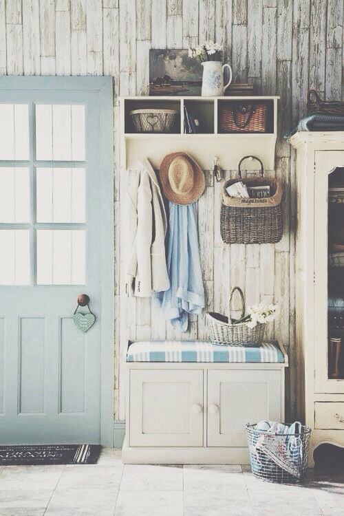 a beautiful shabby chic entryway with whitewashed wooden walls, a storage unit, a cabinet and a seat and a pastel door