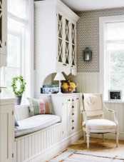 a neutral shabby chic entryway with a whole storage unit, a daybed, lamps, candle lanterns and a vintage chair