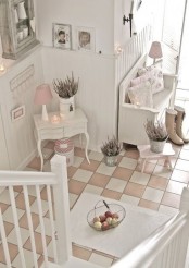 a cozy neutral shabby chic entryway with a bench and a little console, potted blooms, a rough wood cabinet and photos
