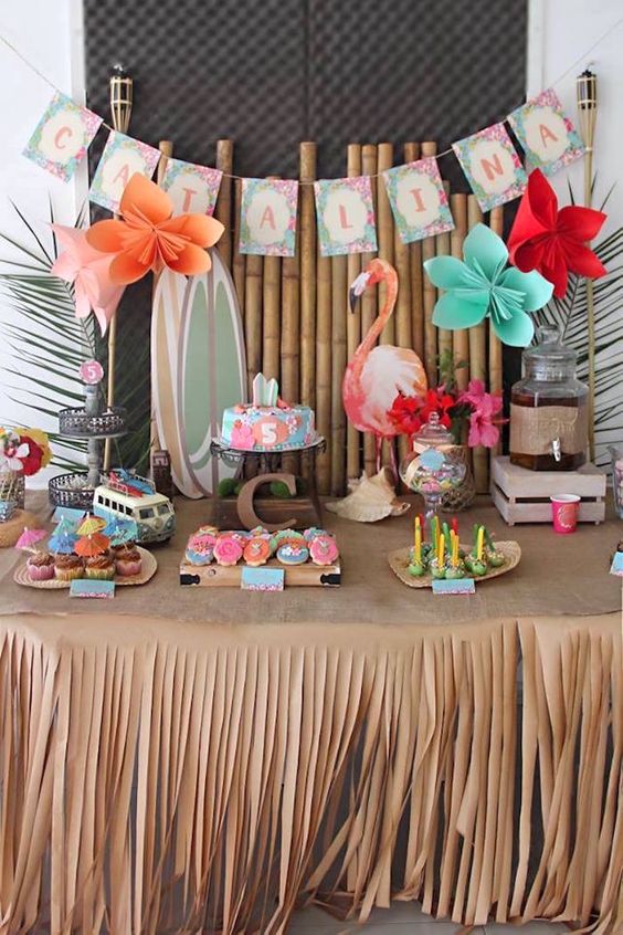 a colorful girl's baby shower dessert table with touches of red, turquoise and peahcy pink, a flamingo, a retro bus and a bright banner