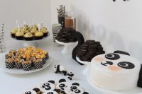 a fun panda-inspired dessert table with a panda banner, panda cookies and a cake plus some black and white sweets
