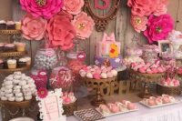 a bright pink and fuchsia dessert table with large paper flowers, touches of brass, monograms and letters