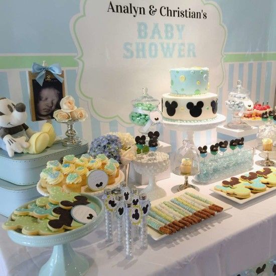 a gender neutral baby shower dessert table done in blue and green, with lots of Mickey Mouse desserts and decorations