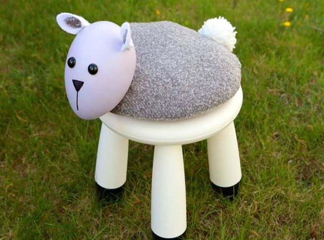 A white IKEA Mammut stool spruced up with a sheep like pillow on top will look fun and cheerful