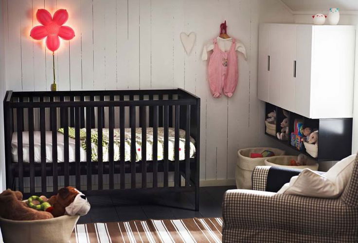A monochromatic nursery with copper touches and a black IKEA Sundvik crib plus neon lights