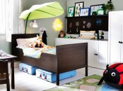 a bold nursery with a chalkboard, white furniture, a dark Sundvik bed, colorful frames, lanterns and fun toys