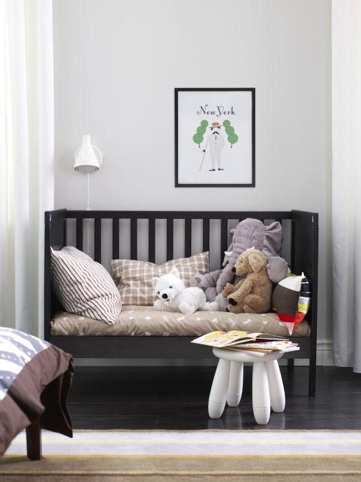 a monochromatic nursery with a dark IKEA Sundvik crib, dark furniture and floors and all neutral everything
