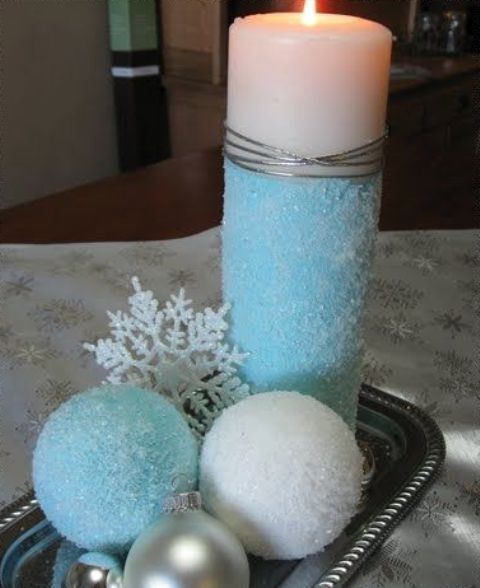 a simple winter or Christmas centerpiece of a tray with blue and usual snowballs, ornaments, snowflakes and a colored candle is lovely