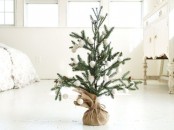 a Christmas tree in burlap, with white snowball ornaments is a pretty and simple winter decoration to rock