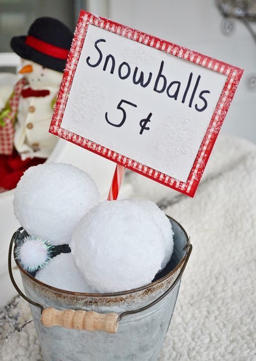 a bucket with large snowballs and a sign is a cool rustic decoration for both indoors and outdoors