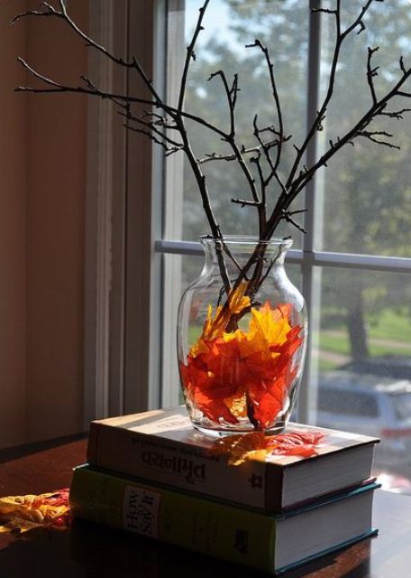 a sheer glass vase with fall leaves, branches and twigs is a simple last minute decoration for the fall