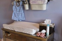 a dresser and a shelf with hooks plus railing and hanging buckets for storing various stuff