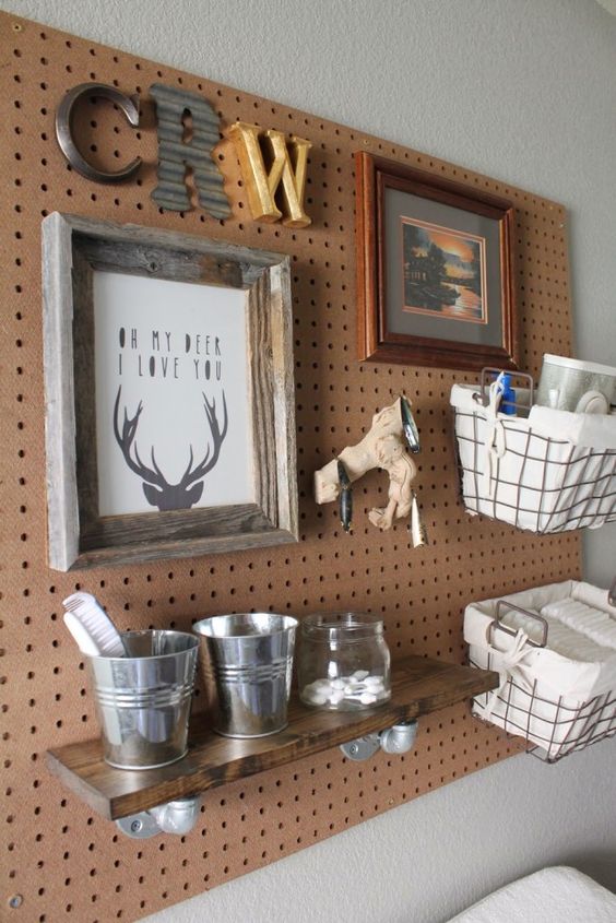 a pegboard with wire baskets, a shelf and even some art is a cool piece to hang over the changing table