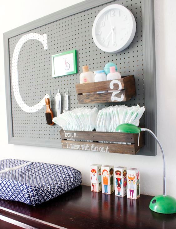 a pegboard pver the changing table with dark stained pallet boxes, monograms and hooks