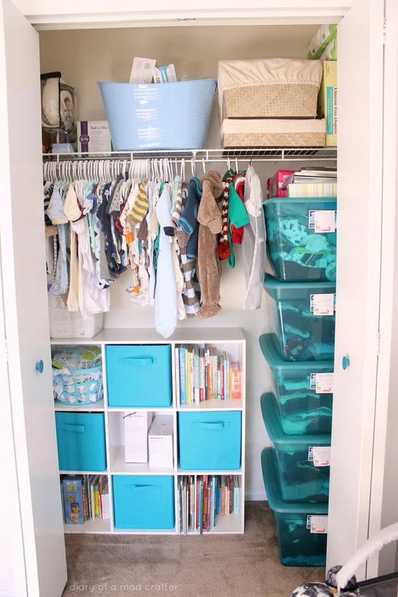 a closet with lots of hangers and a storage units with open compartments and drawers