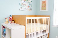 boxes inserted under the bed and a shelving unit next to it to store and organize stuff in your nursery