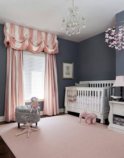 a refined grey and blush nursery with graphite walls, white furniture and pink and blush textiles