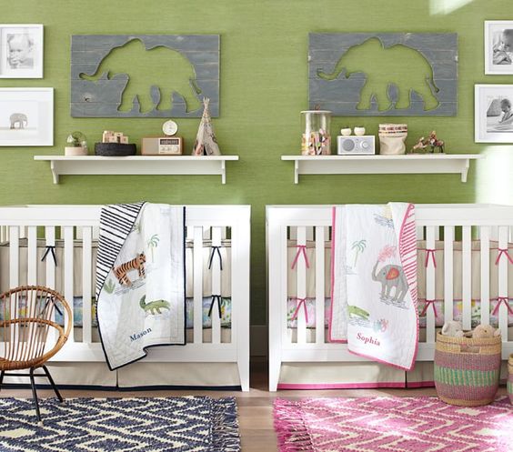 a green, grey and white shared nursery with white furniture, gallery walls and figurines on display