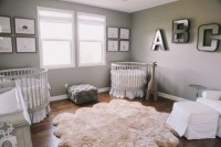 a gender neutral shared nursery with grey walls, white furniture, two gallery walls, matching cribs and monograms on the wall