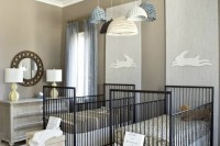 a gender neutral shared nursery with neutral furniture, black cribs, printed bedding and touches of grey and blue, with crochet lamps