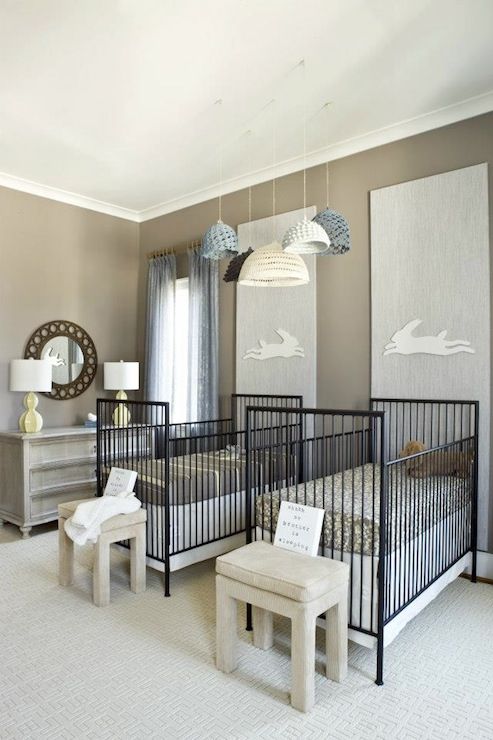 a gender neutral shared nursery with neutral furniture, black cribs, printed bedding and touches of grey and blue, with crochet lamps
