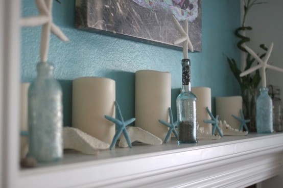 a blue and neutral beach mantel with blue starfish, candles, bottles with starfish stoppers