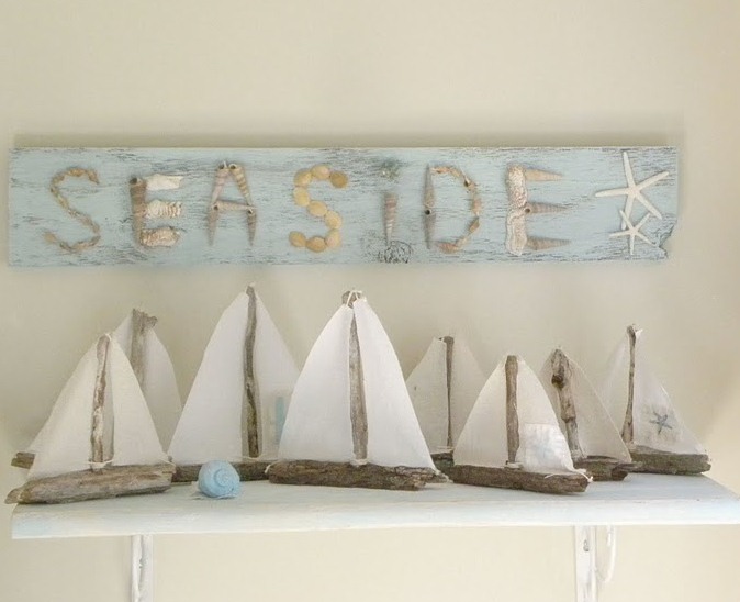 Simple DIY boats and a blue beach sign over the mantel, some seashells and starfish for a beach mantel