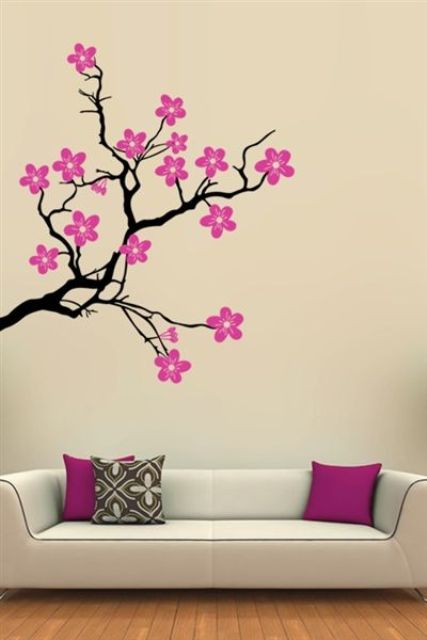 bright cherry blossom decals on the wall over the sofa echoes with the pillows and makes the space bolder
