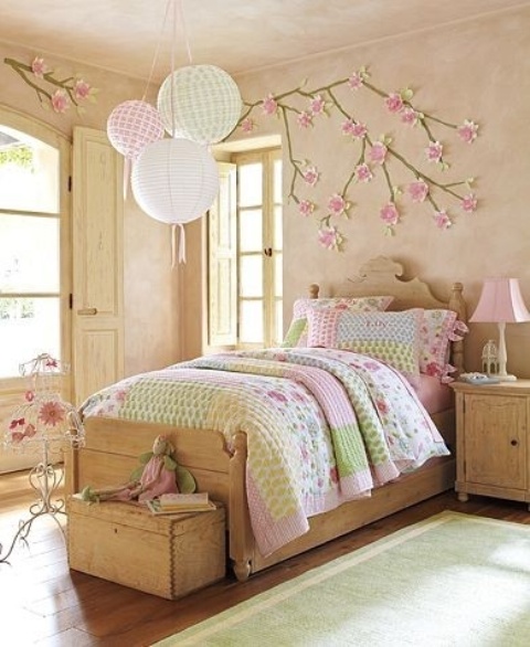 a vintage-inspired kid's bedroom with cherry blossom on the wall that accents the decor of the room