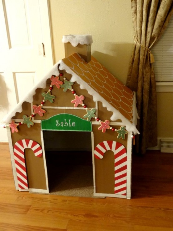 a gingerbread-style dog house of cardboard with candy canes and gingerbread men garlands is a cool idea for the holidays