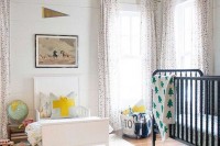 a neutral shared space with printed curtains, contrasting beds and some bright touches here and there