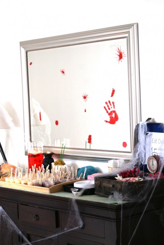 an oversized mirror in a silver frame with bloody hand marks and a jar full of blood will hint on the theme of your party in a delicate way
