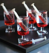 glasses with syringes filled with blood – style your Halloween party drinks like this to make it more fun and bold