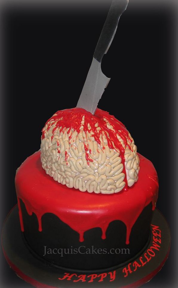 A black cake with red drip topped with a bloody brain topped with a knife is a bold solution for a blood themed or Dexter themed wedding