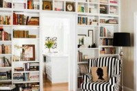 a doorway wall with open bookshelves is a cool idea to save some space while storing books and to use a blank wall over the door