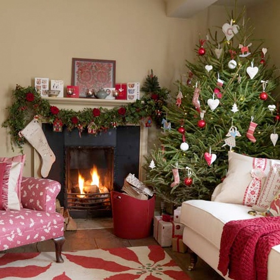 A Christmas tree with red and white ornaments, a garland with red blooms and gift boxes make the space feel Scandinavian and holiday like