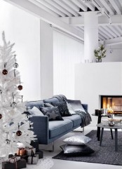 a minimalist living room with a white Christmas tree decorated only with brown and silver sequin ornaments – that’s all you need in such a space to create a mood