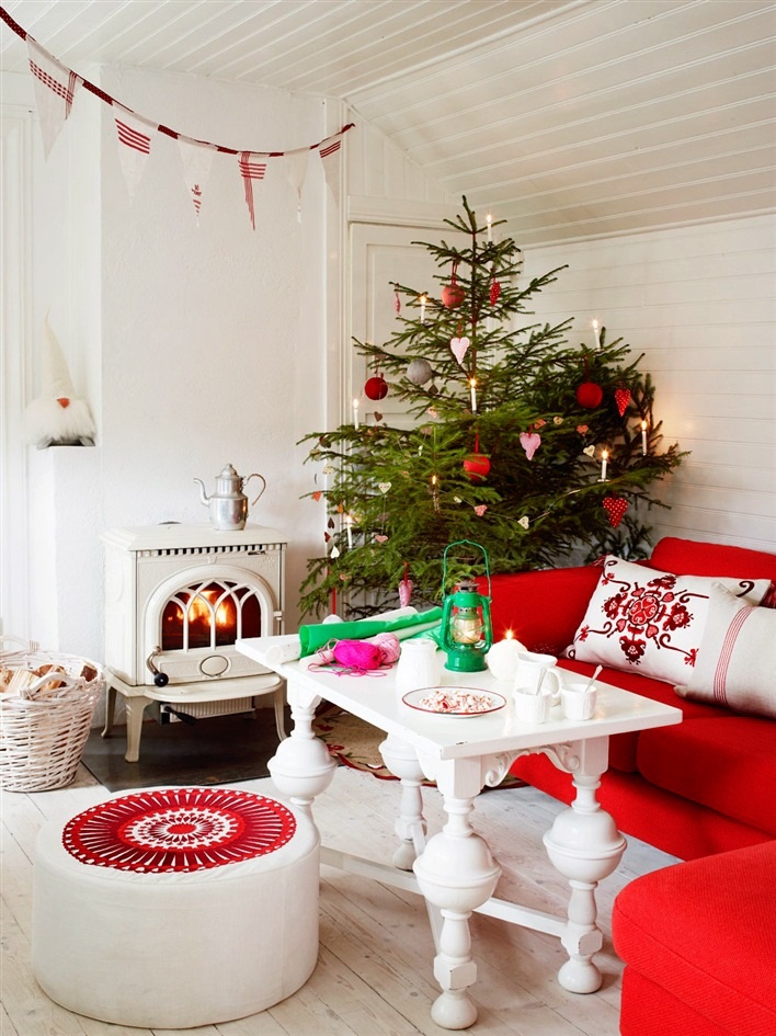 A red and white Scandinavian Christmas living room with matching holiday decor   a Christmas tree with red and white ornaments, a red and white fabric banner over the space