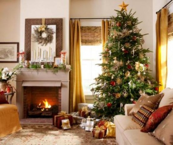 a Christmas tree with lights, red and gold ornaments, a fir garland, candles, a branch wreath and lots of gifts under the tree