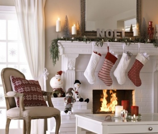 printed red and white Christmas stockings, fir garlands, lights, candles and printed pillows for bright holiday decor